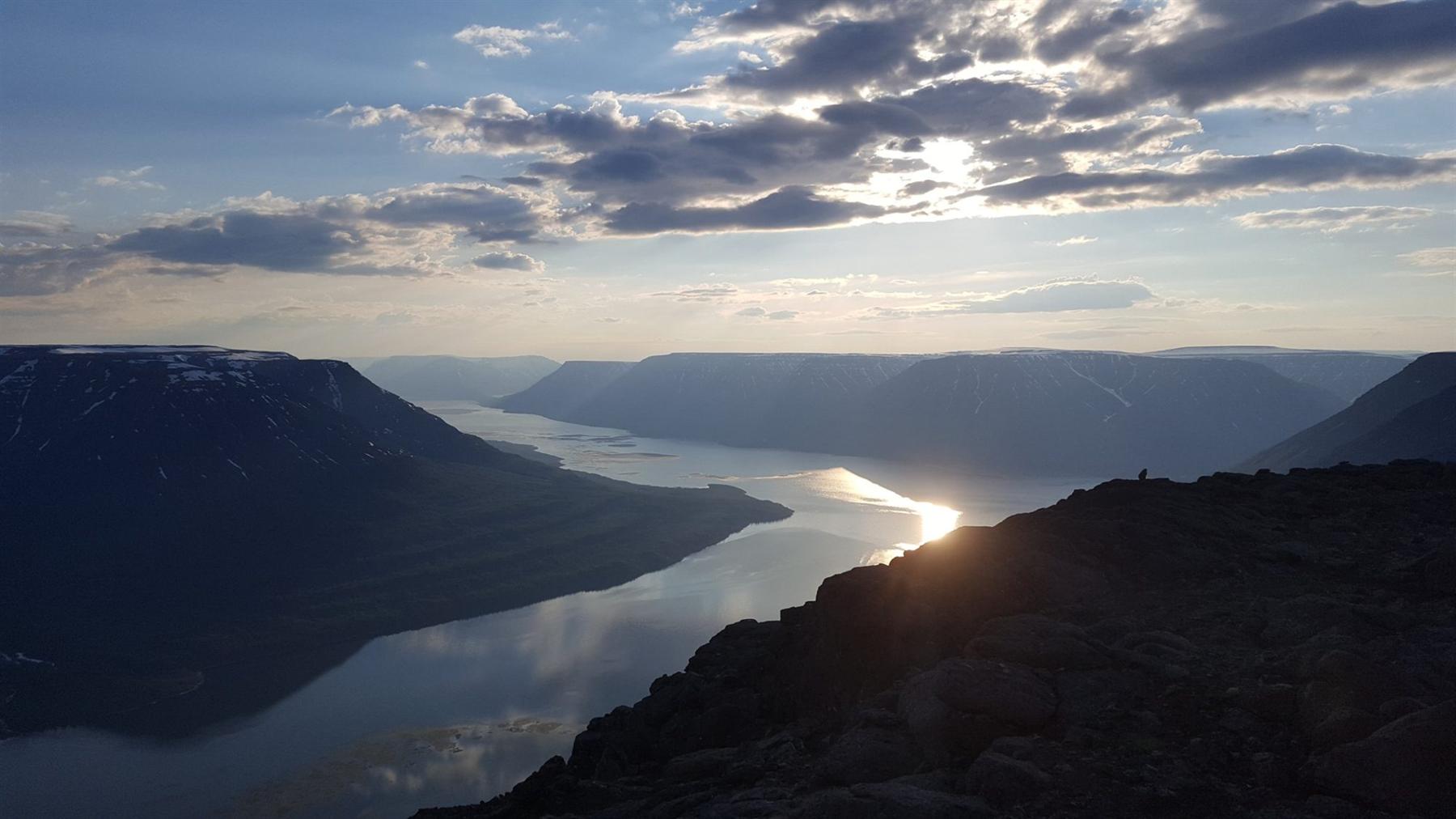 A lake winding between the flat-topped mountains of the Putorana Plateau