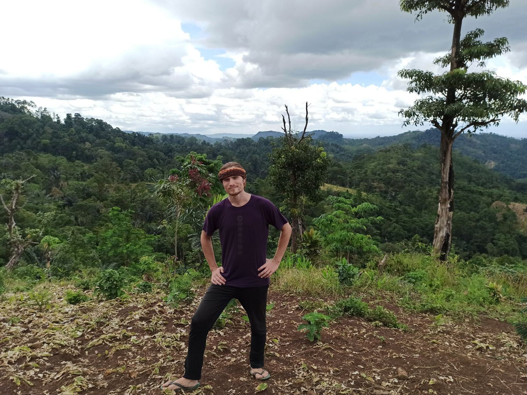 Igor standing on a forested hilltop above rolling jungle
